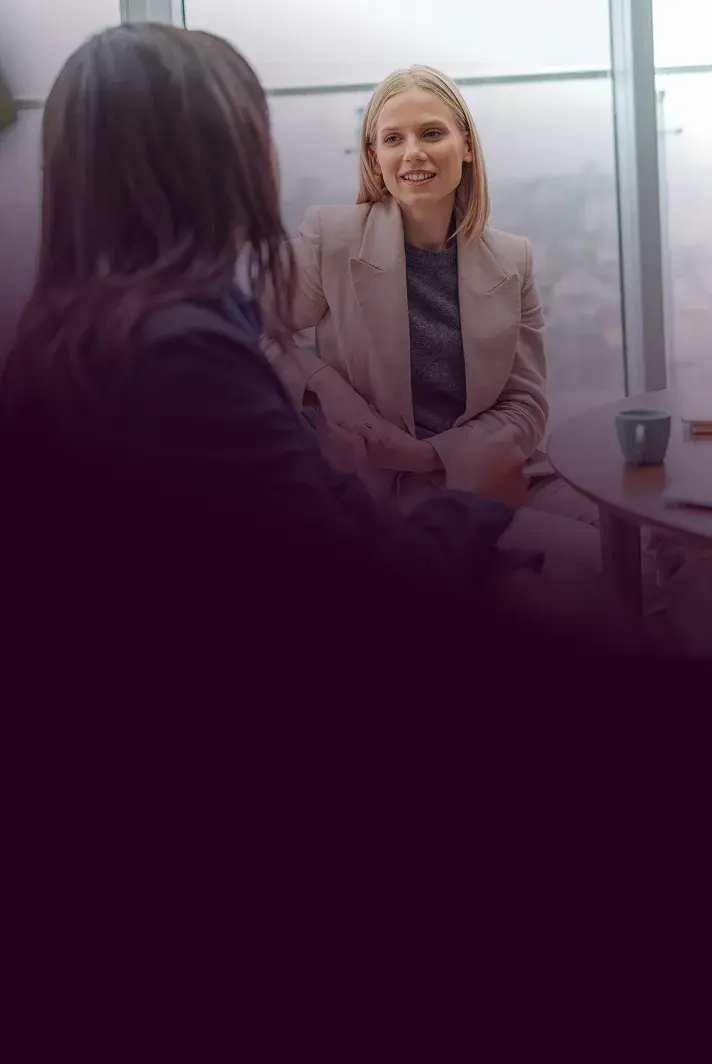 A broker smiling while meeting with a client